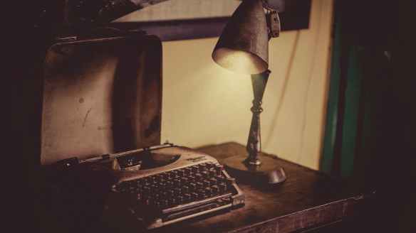 sephia photography of desk lamp lightened the gray typewriter on wooden table