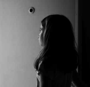 grayscale photography of girl near wall