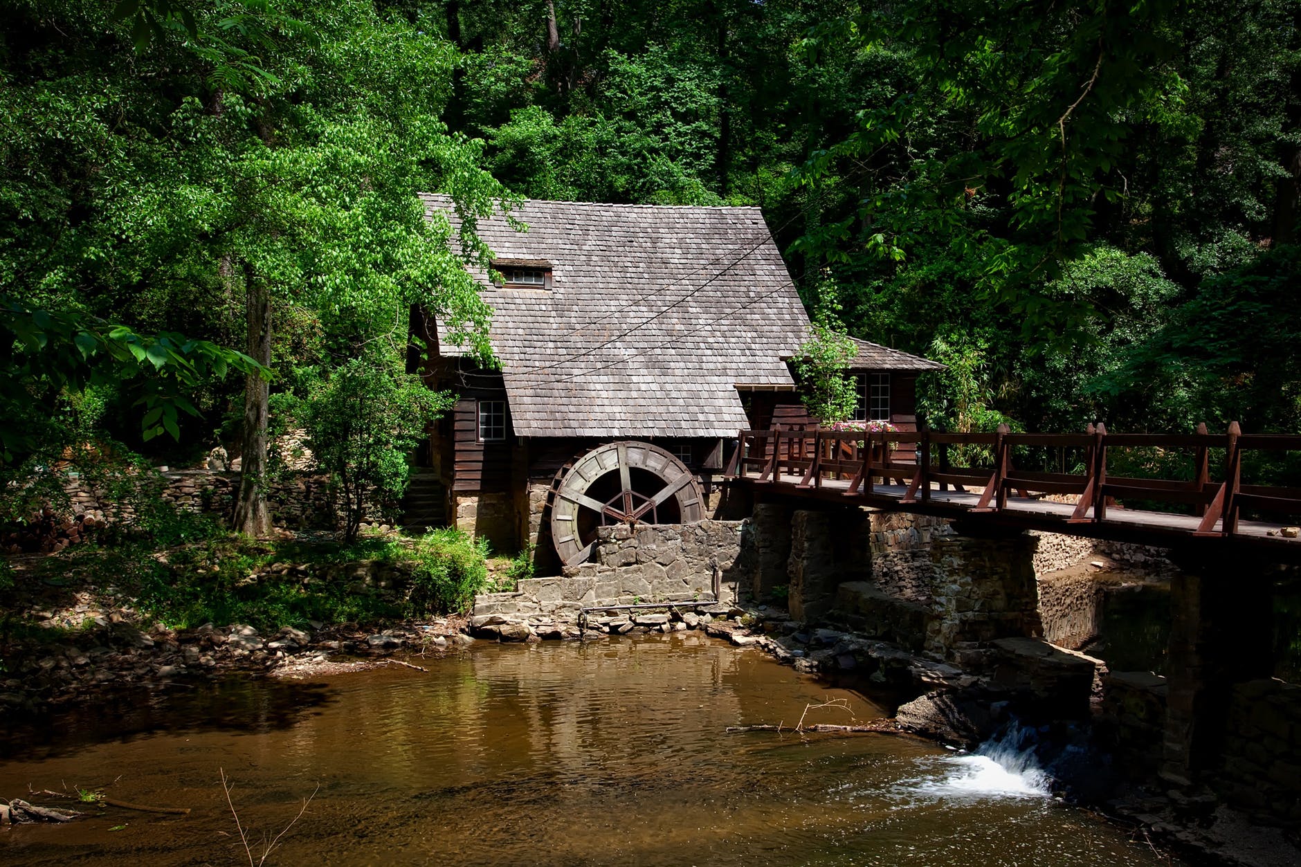 brown house near river trees and bridge