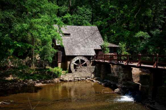 brown house near river trees and bridge