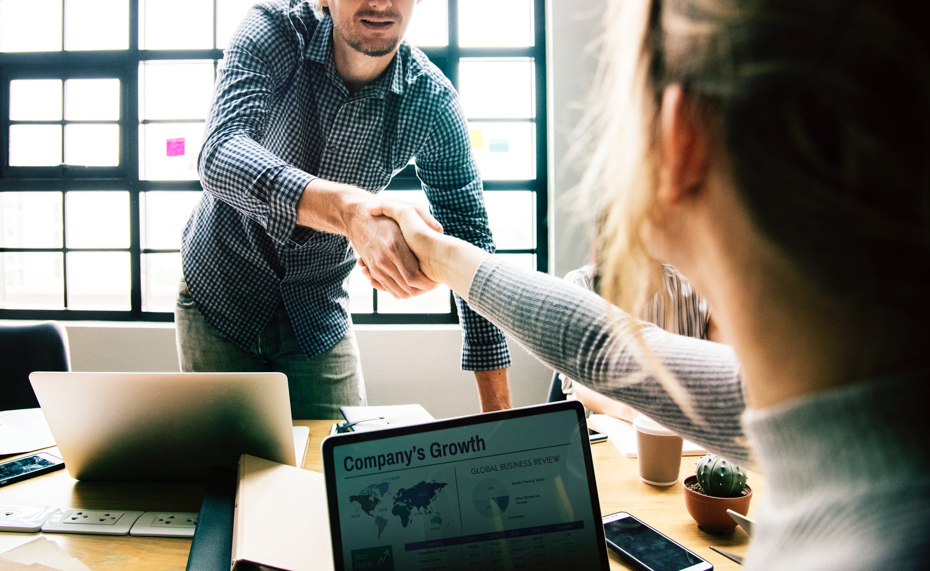 man shaking hands with woman