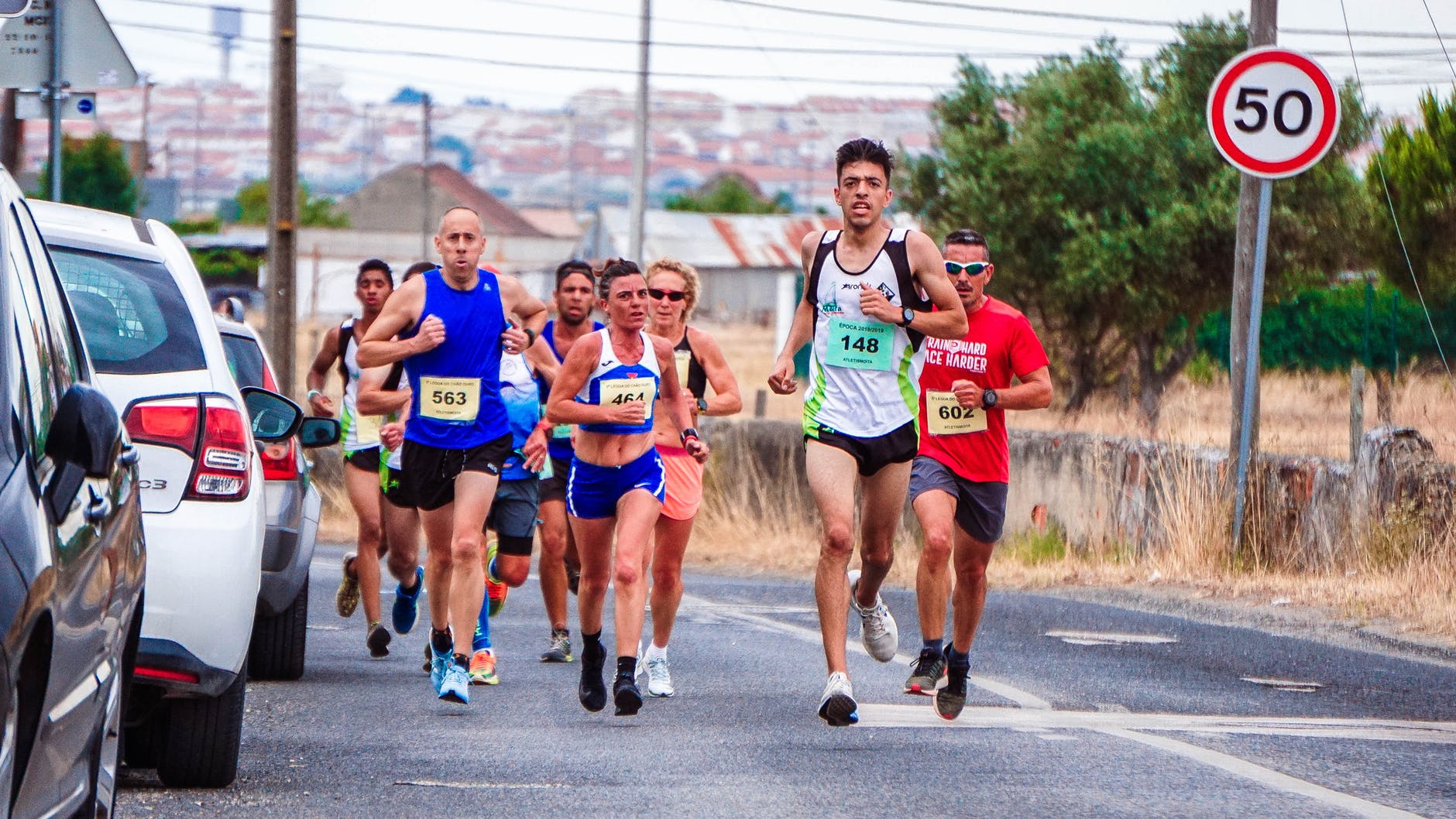 photo of people running beside parked vehicles