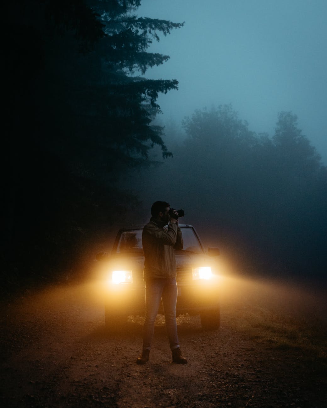 man taking photo in front of vehicle