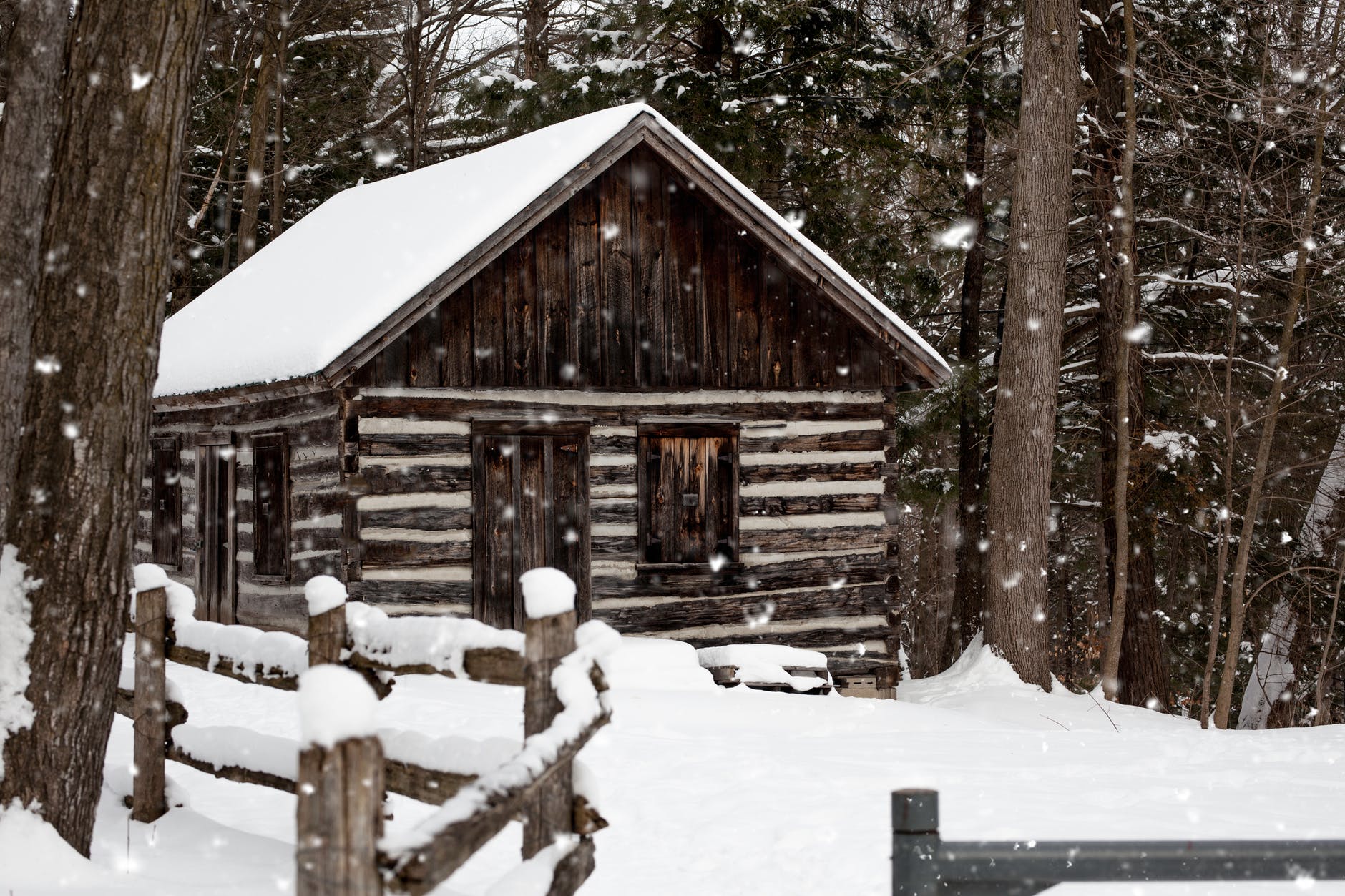 snowy brown house near tree