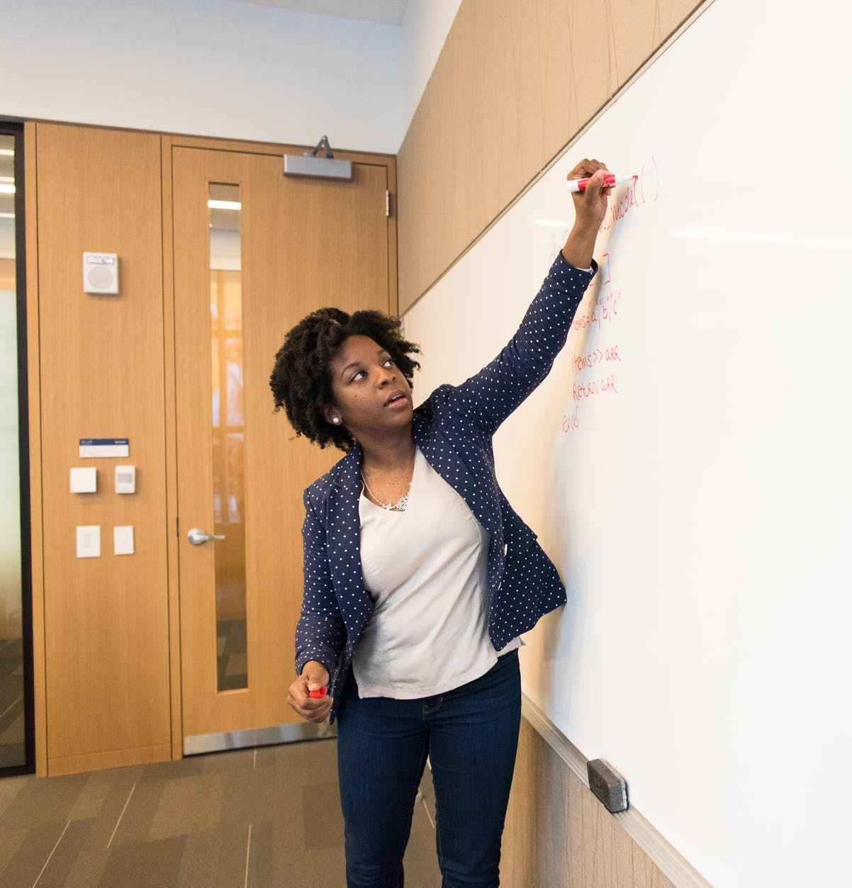 woman writing on dry erase board