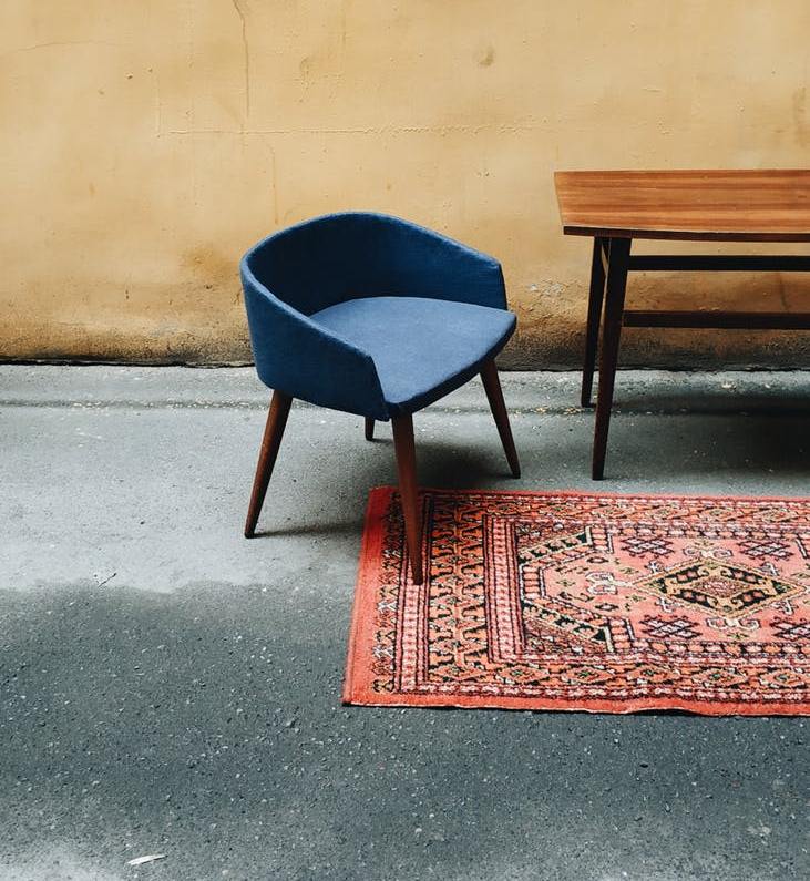 a blue chair and wooden table in a room