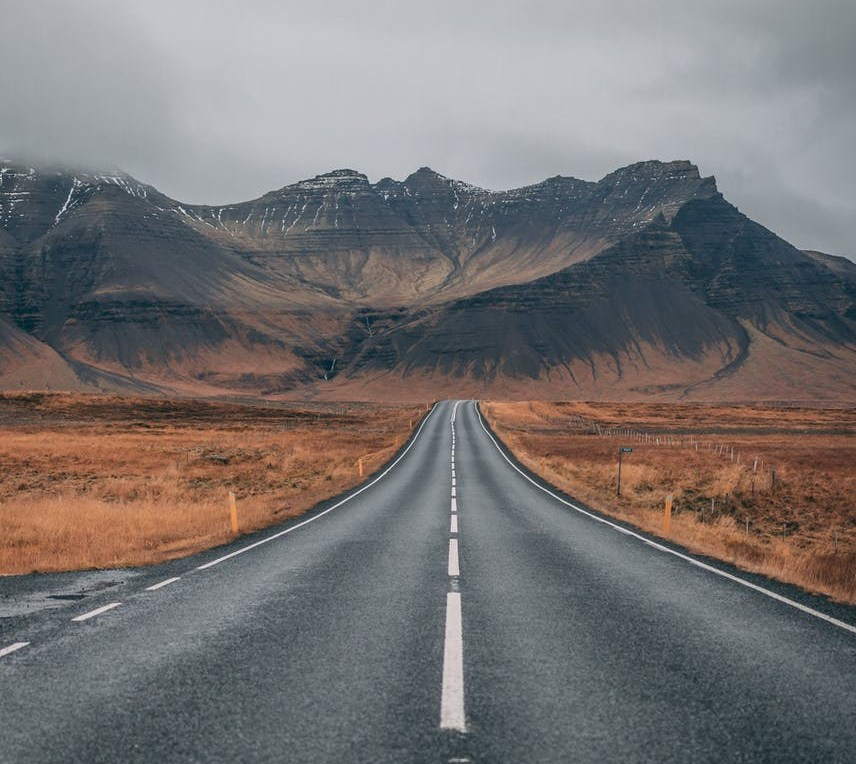empty highway overlooking mountain under dark skies