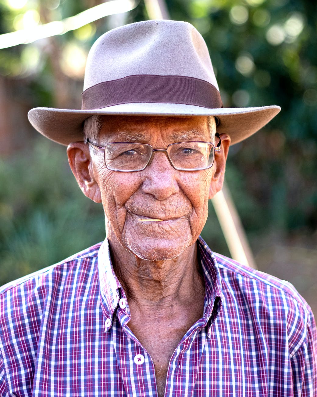 man wearing gray and brown hat with eyeglasses