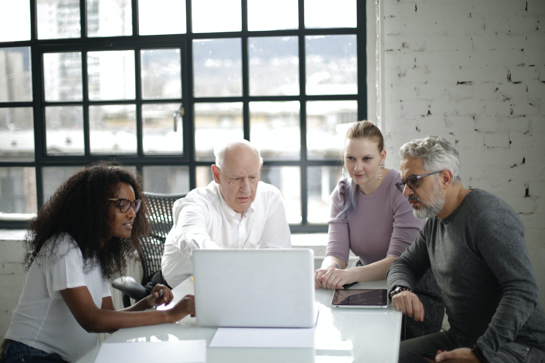 man in white long sleeved shirt presenting on a laptop
