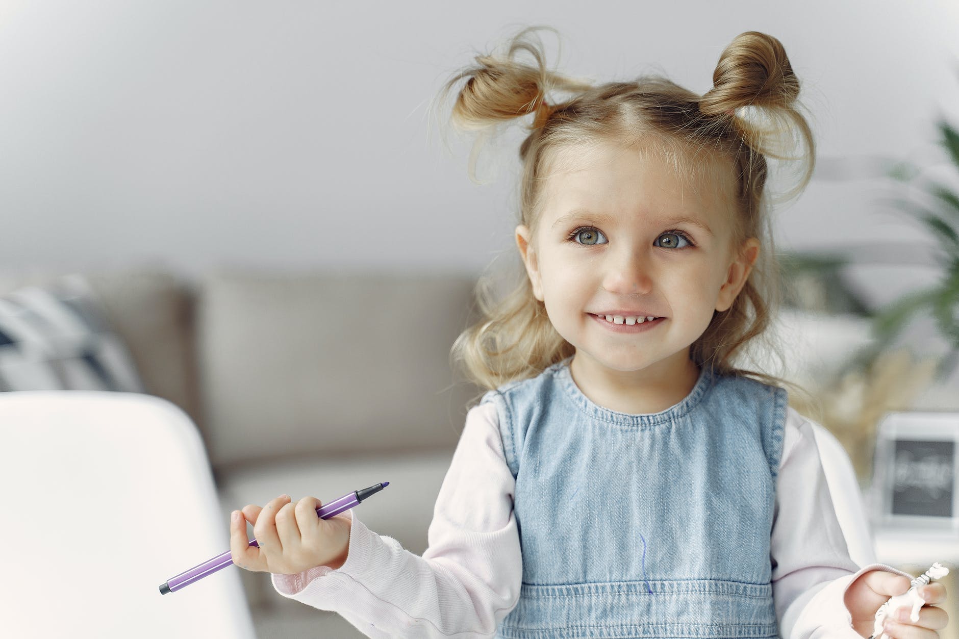 cute little girl holding purple color pen