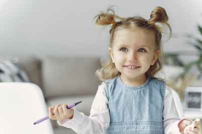 cute little girl holding purple color pen