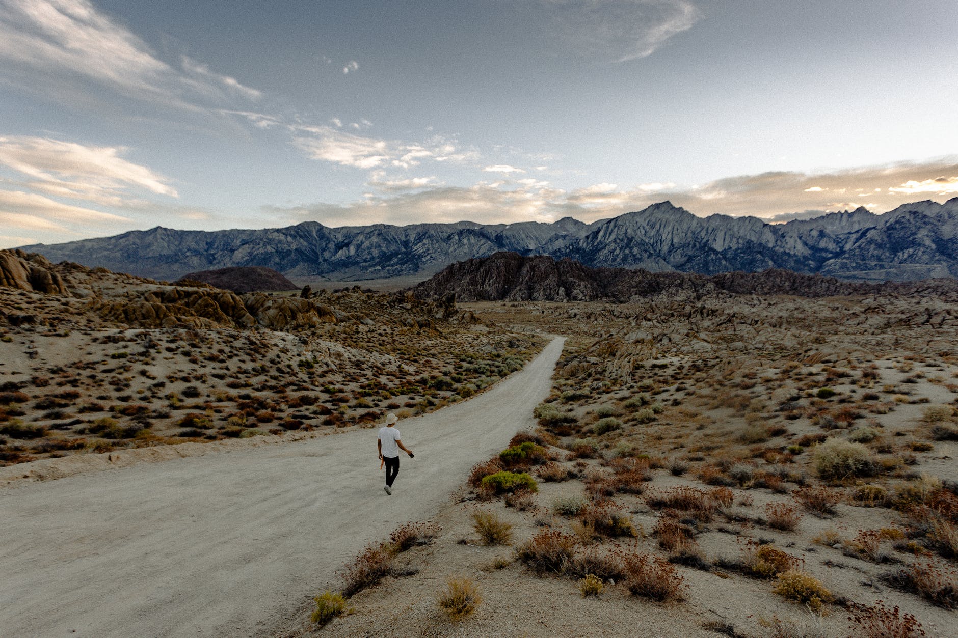 person wearing white shirt walking on dirt road
